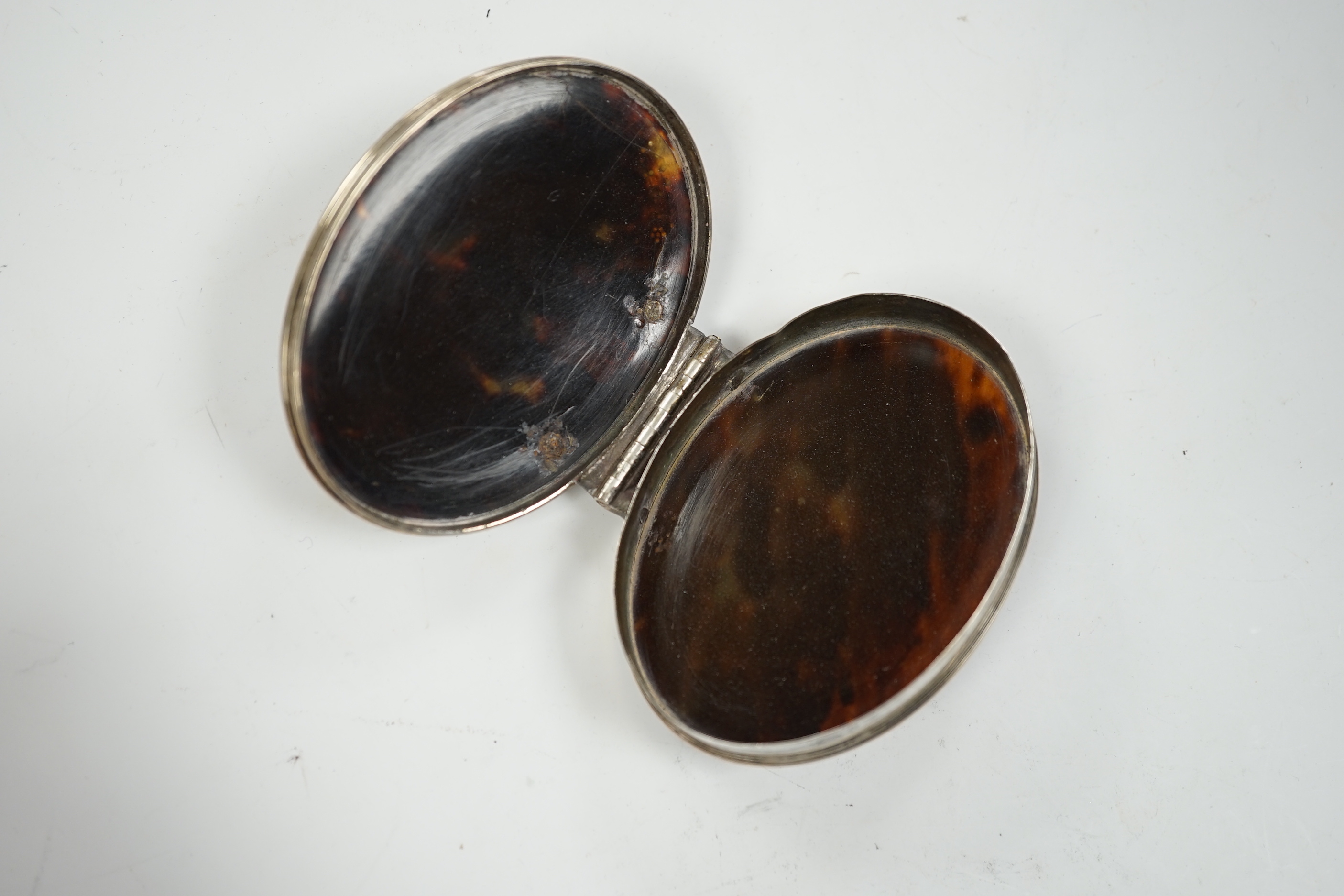 An 18th century white metal mounted tortoiseshell pique oval snuff box, 70mm.